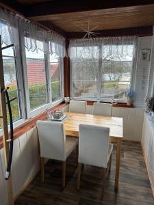 a dining room with a wooden table and white chairs at Katka in Cheb