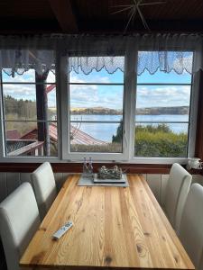 a dining room with a table and two large windows at Katka in Cheb