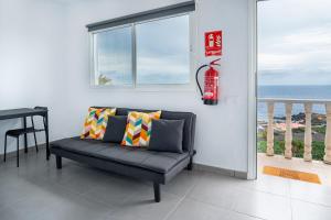 a couch in a living room with a window and a fire hydrant at Vivienda Vacacional Tinisagua 3 in Breña Alta