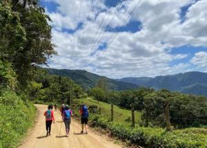 a group of people walking down a dirt road at Los Cipreses Eco Hotel in Sonsonate