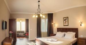 a bedroom with a bed and a chandelier at Hotel Vila Bregu in Tirana