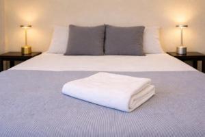 a white bed with two lamps on two tables at Los Cipreses Eco Hotel in Sonsonate