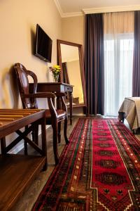 a living room with a table and a piano at Hotel Vila Bregu in Tirana