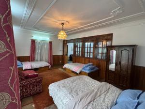 a room with three beds and a chandelier at Pahuna Homestay in Kathmandu