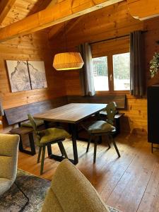 a dining room with a wooden table and chairs at Blockhäuser Stamsried in Stamsried