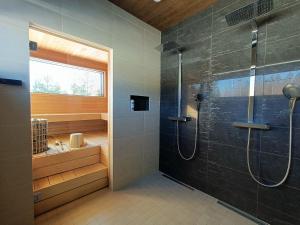 a bathroom with a shower and a sink at Luksushuvila yksityisellä SPA-alueella ja järvinäköalalla in Ähtäri