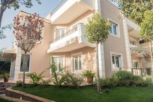 an apartment building with trees in front of it at Hotel Vila Bregu in Tirana