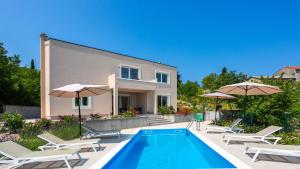 a villa with a swimming pool in front of a house at Casa Tijana by Villas Guide in Krk