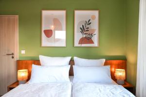 a bedroom with green walls and two beds with white pillows at Ferienwohnung Elbhang mit Stellplatz in Königstein an der Elbe