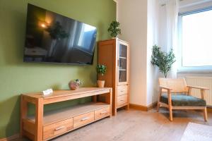 a living room with a tv on a green wall at Ferienwohnung Elbhang mit Stellplatz in Königstein an der Elbe