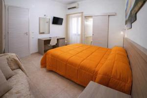 a bedroom with an orange bed and a desk at Villa Merina in Vieste