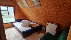 a small room with a bed and a window at Viešnagė gamtos prieglobstyje in Gūragiai +6 photos