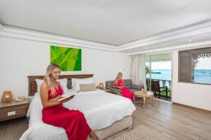 two women sitting on a bed in a hotel room at The Taksim Royal Beachfront Resort in Patong Beach