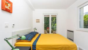 a bedroom with a yellow bed and a window at Casa Tijana by Villas Guide in Krk +32 photos