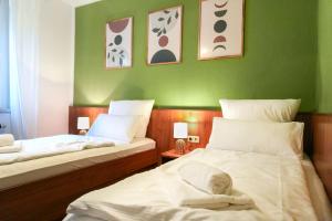 two beds in a room with green walls at Ferienwohnung Elbhang mit Stellplatz in Königstein an der Elbe +7 photos