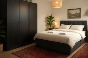 a bedroom with a large bed with a black cabinet at Hannover Group Apartment in Hannover