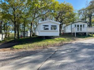 a white house on the side of a road at Stylish large static caravan gold rated 3BR Slp 8 Thorness Bay in Porchfield