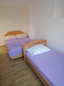 two beds in a small room withermottermott at Vila Ruška in Prčanj