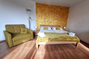 a bedroom with a bed and a couch and a chair at Penzión Villa Agnes in Smolenice