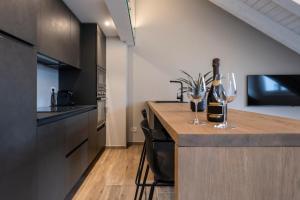 a kitchen with two wine glasses on a counter at Ariel Penthouse - In the heart of Domodossola in Domodossola
