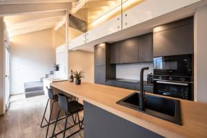 an open kitchen with a counter and a sink at Ariel Penthouse - In the heart of Domodossola in Domodossola