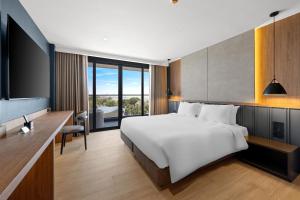 a bedroom with a large white bed and a television at The Turtle Hotel Bangsaen in Ban Thai Don (1) +54 photos