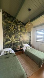 a bedroom with two beds and a tropical wallpaper at Maison Familiale avec Jardin & Parking privé in Les Sables-d'Olonne