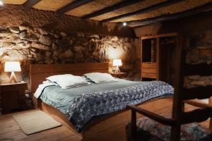 a bedroom with a bed in a stone wall at Hotel Rokas de Suesca in Suesca