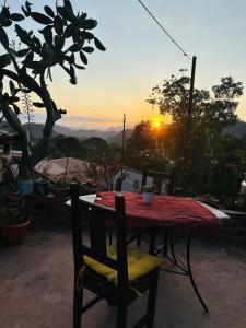 a table and chairs with the sunset in the background at Guest House Don Moisés in Copán Ruinas