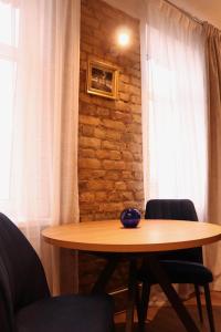 a wooden table with two chairs and a window at Cozy Alauksta apartment in Riga