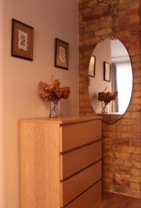 a dressing room with a mirror and a wooden dresser at Cozy Alauksta apartment in Riga