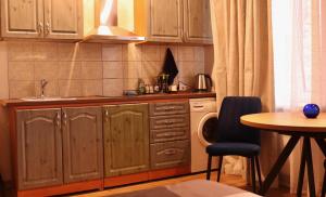 a kitchen with wooden cabinets and a table and a sink at Cozy Alauksta apartment in Riga