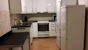 a kitchen with white cabinets and a white refrigerator at Bodø Apartment in Bodø