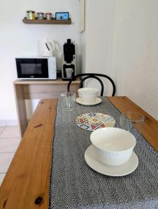 a wooden table with two bowls and plates on it at Studio 09 in Sulniac