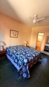 a bedroom with a bed with a blue blanket at Varanda do Mar Pitangueiras - 4 Quartos - Até 10 Pessoas - 2 Vagas in Guarujá