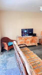 a living room with a couch and a flat screen tv at Varanda do Mar Pitangueiras - 4 Quartos - Até 10 Pessoas - 2 Vagas in Guarujá