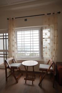 a room with two chairs and a table and a window at Sanobar Home Stay in Bhīm Tāl