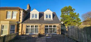 a brown house with a fence in front of it at 12A-1 Stobhill Road in Arniston