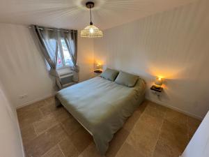 a bedroom with a bed with two lamps on it at Maison 4 personnes in Saint-Julien
