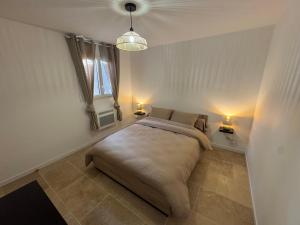 a bedroom with a bed with two lamps and a window at Maison 4 personnes in Saint-Julien