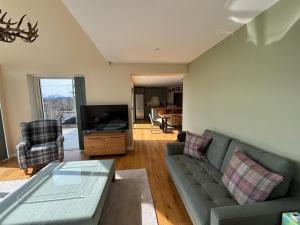 a living room with a couch and a tv at Sunny Ridge in Fort Augustus