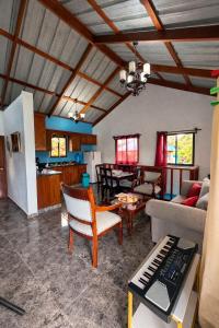 a living room with a piano and a kitchen at Villa azul círculo auto in Jarabacoa