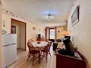 a kitchen and living room with a table and a refrigerator at Charmant logement de plain-pied avec Piscine in Loudenvielle