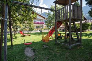 a playground with three swings in a yard at Ferienwohnung Eder in Gais