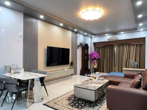 a living room with a couch and a tv at Phốstay 180 Cầu Đất in Hai Phong