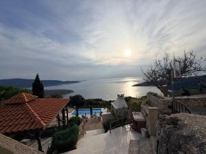 a view of the water from a house with the sun at Vita Vacation Home in Ustrine