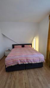 a bedroom with a bed with a striped comforter at Ferienwohnung Annaberg-Buchholz,5 in Annaberg-Buchholz