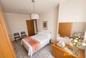 a bedroom with a bed and a vase of flowers at a casa di BIRI in Trezzo sullʼAdda