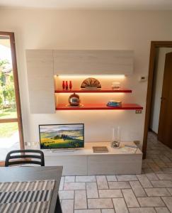 a living room with a table and a tv on a wall at a casa di BIRI in Trezzo sullʼAdda