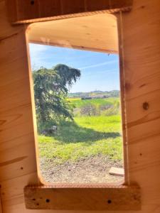 a view of a tree from a wooden window at Cabane étape in Idrac-Respailles
